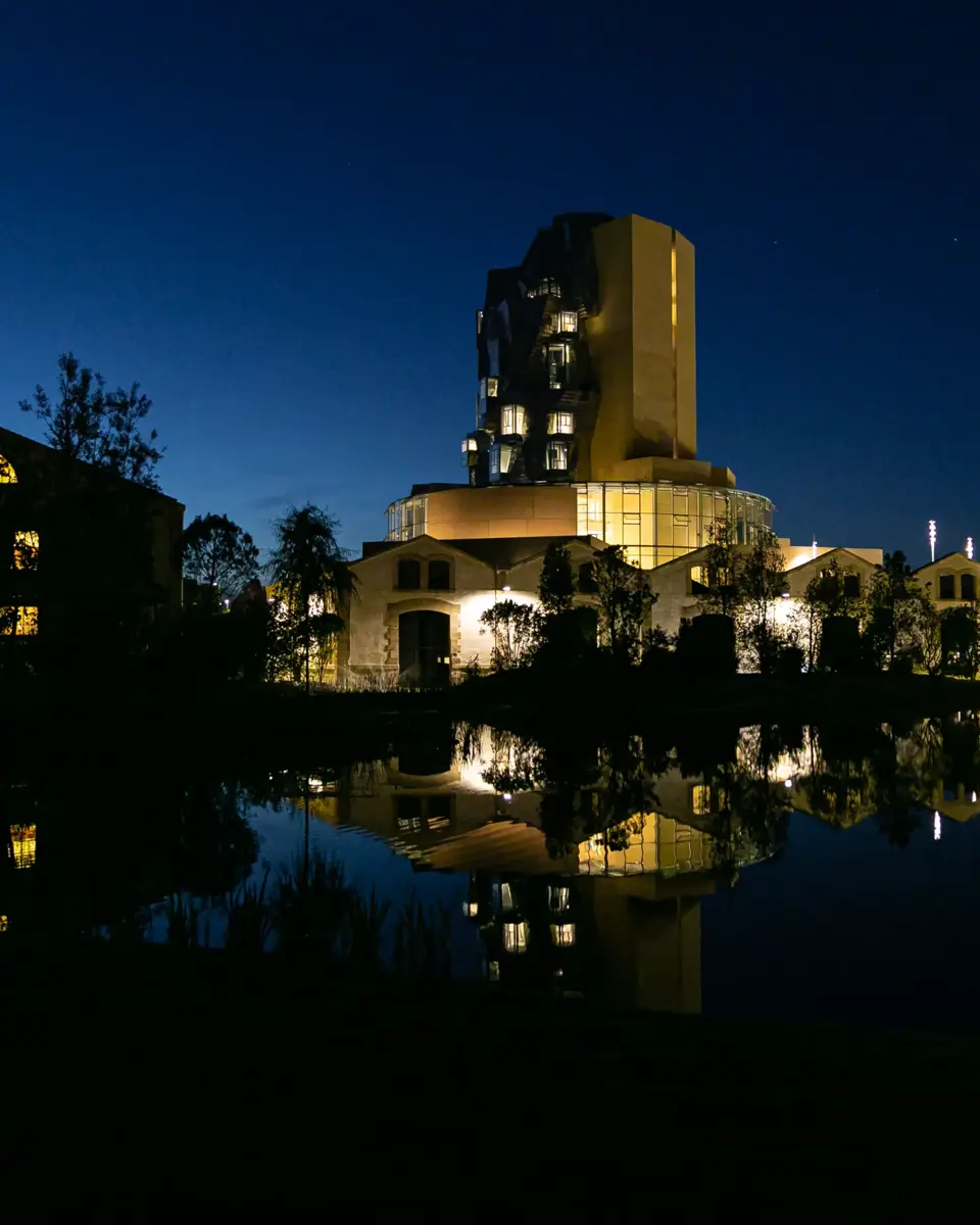 Night view of the Parc des Ateliers in Arles, with The Tower by Frank Gehry in the background and the pond in the foreground